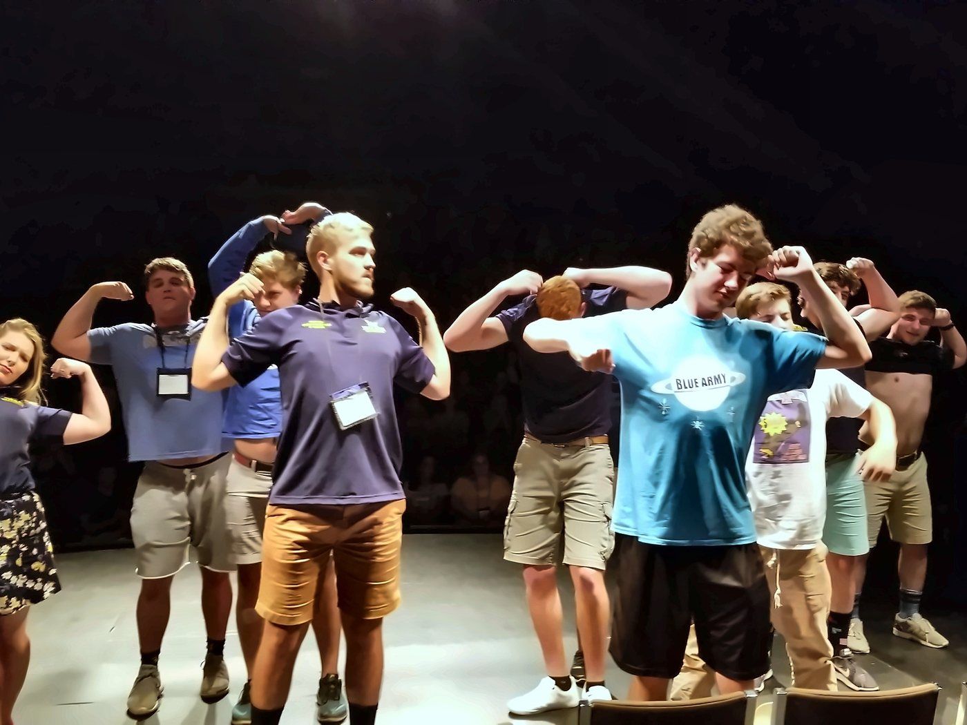 Hypnotized students flexing on stage