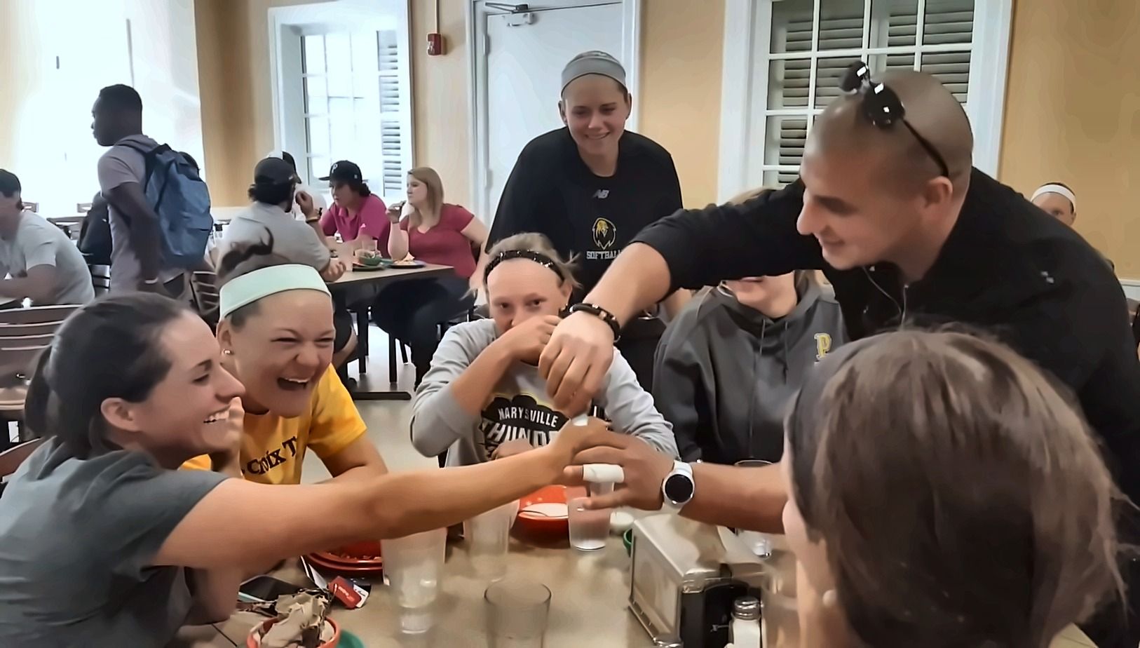 Guests laughing as Eric Mina performs close-up magic at their table