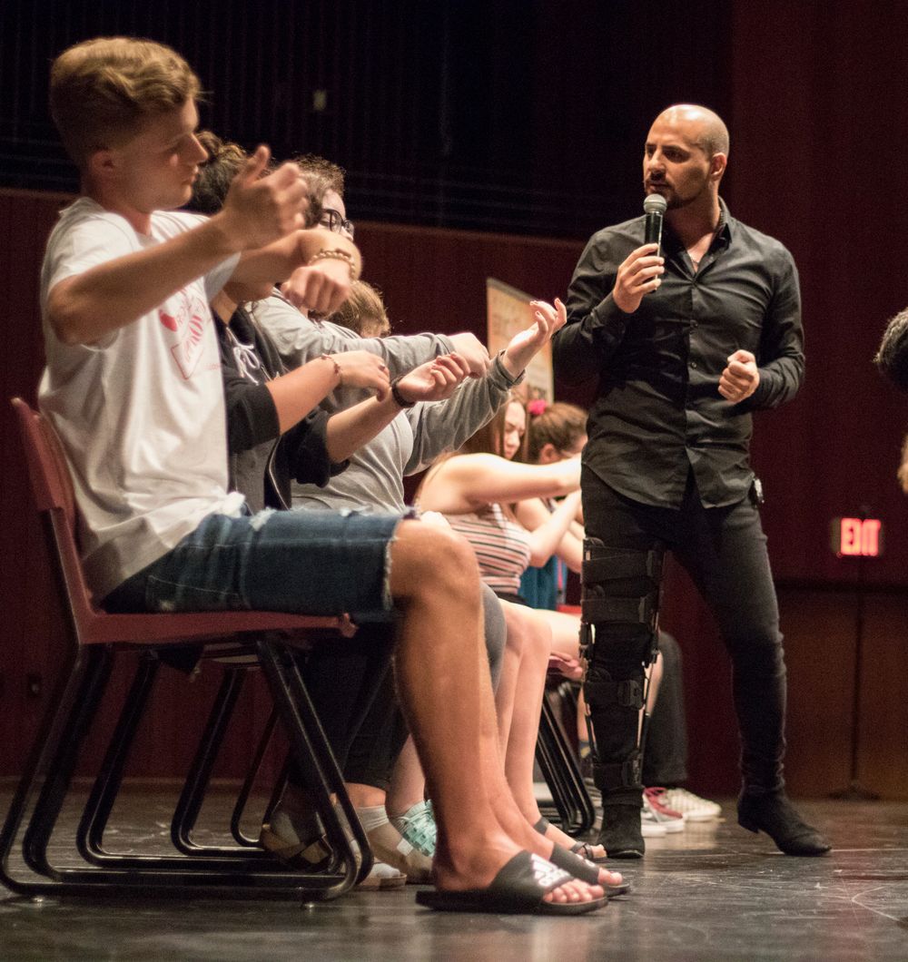 Student volunteers on stage during Eric Mina's show