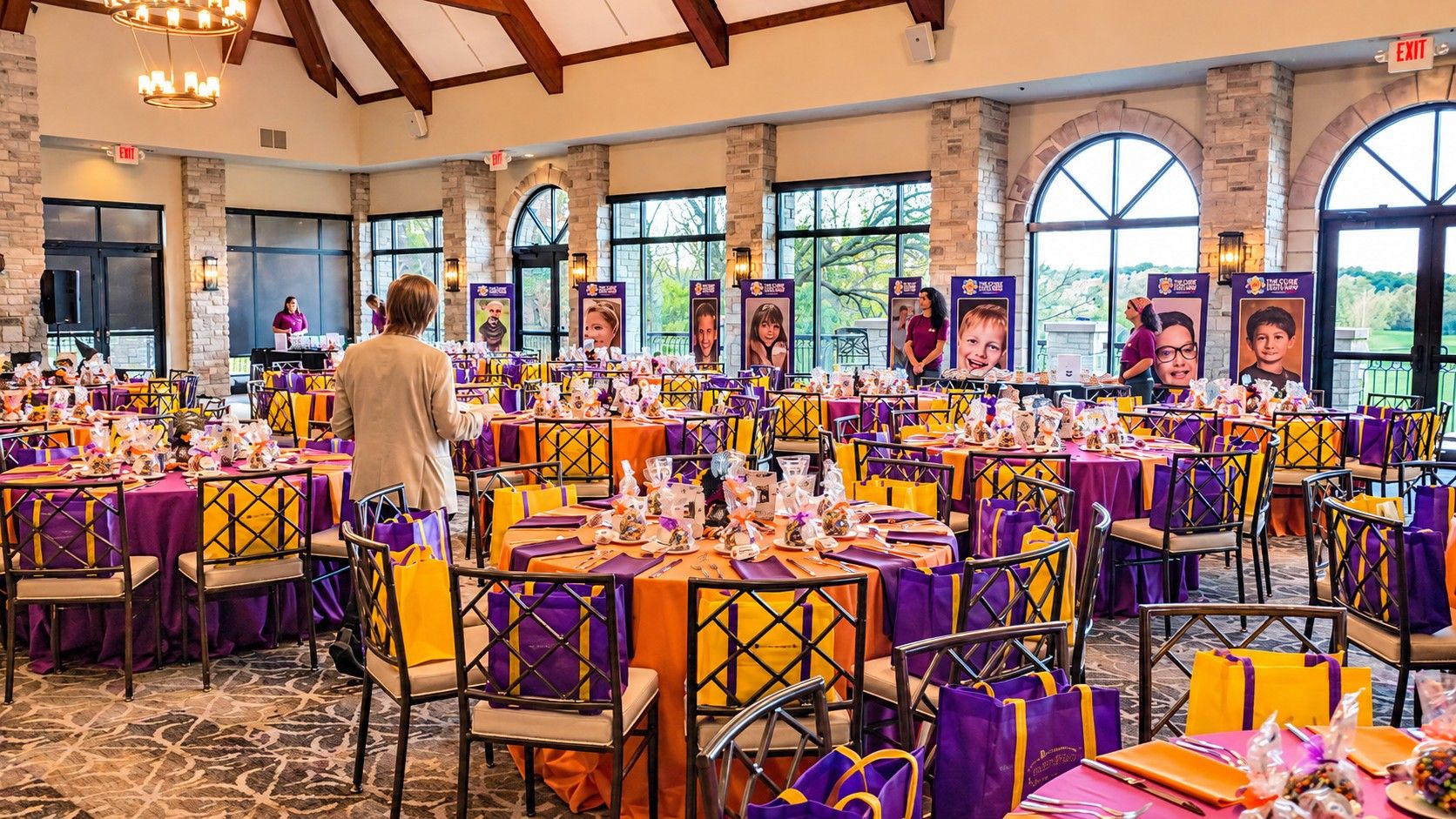 The Galaween ballroom at The Legend at Brandybrook set in purple and orange, with photos of the kids the chapter supports