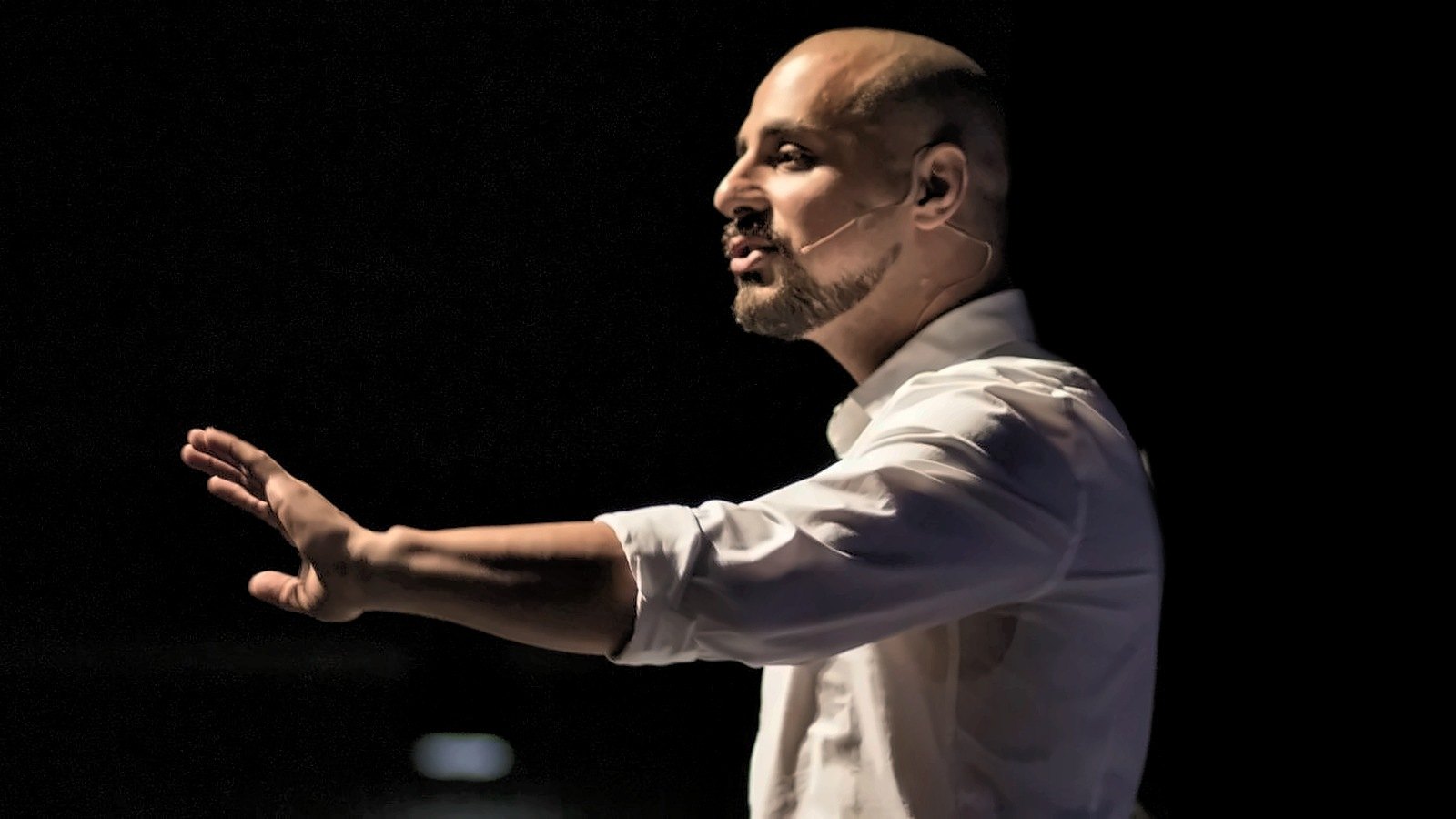 Eric Mina guiding the audience from the stage