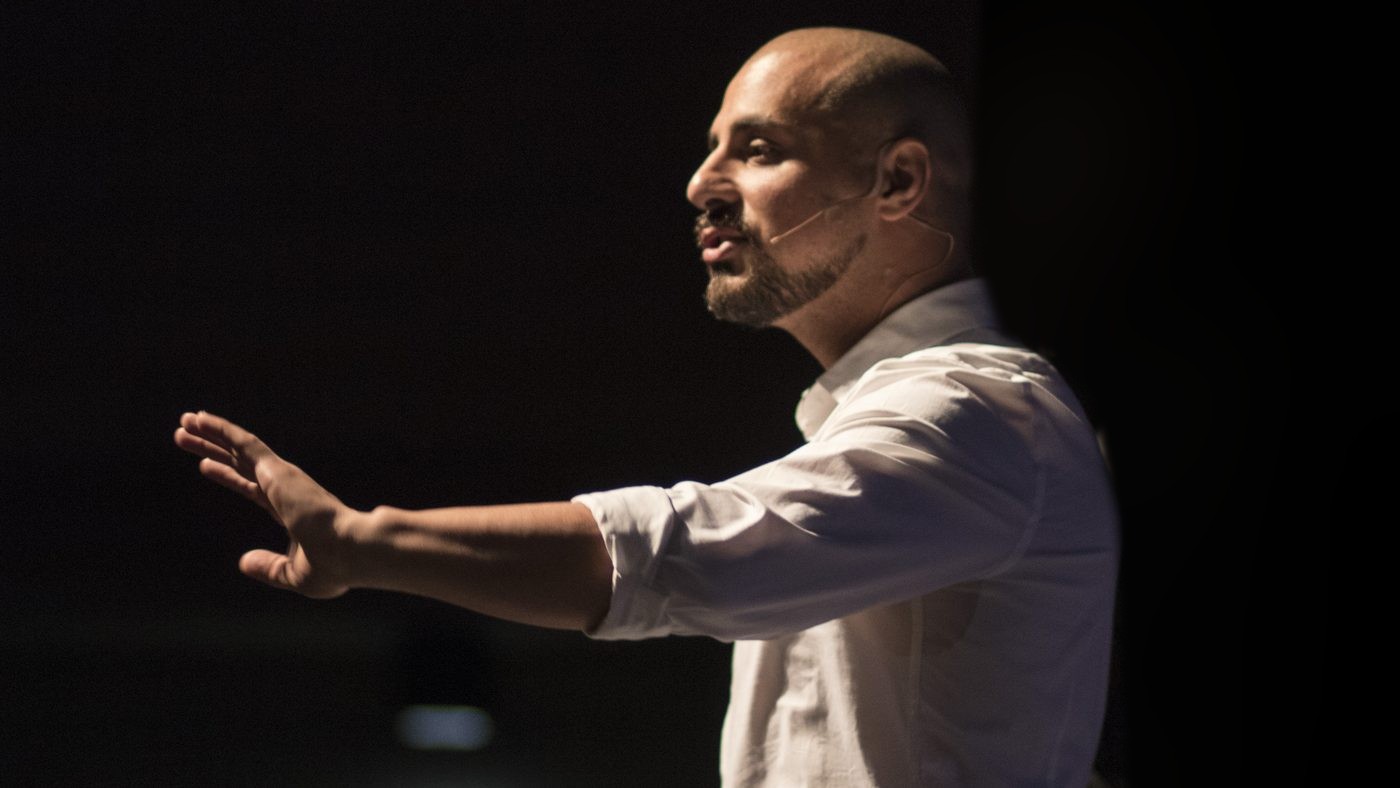 Eric Mina guiding a volunteer on stage